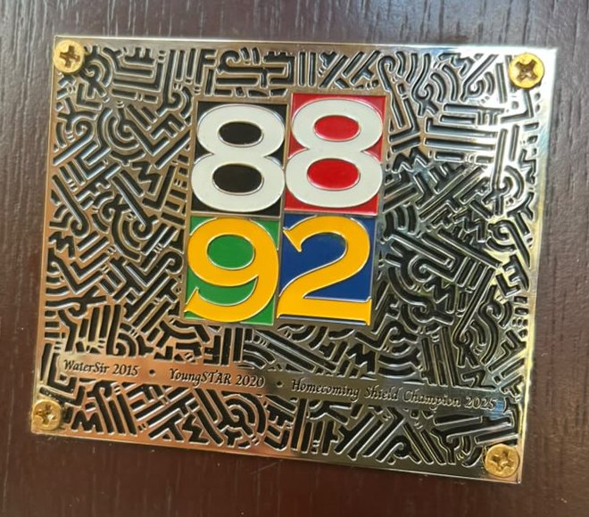 The 88/92 batch plaque on the school shield board, engraved WaterSir 2015, YoungSTAR 2020, Homecoming Shield Champion 2025